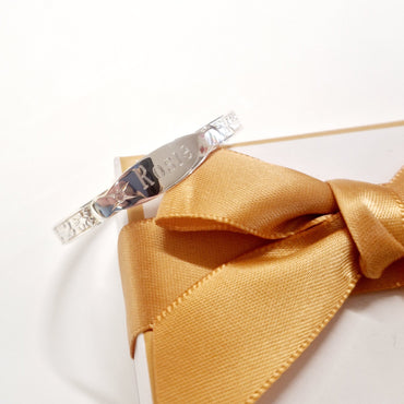 Close-up of sterling silver christening bangle with delicate pink stone detail - Eva Victoria