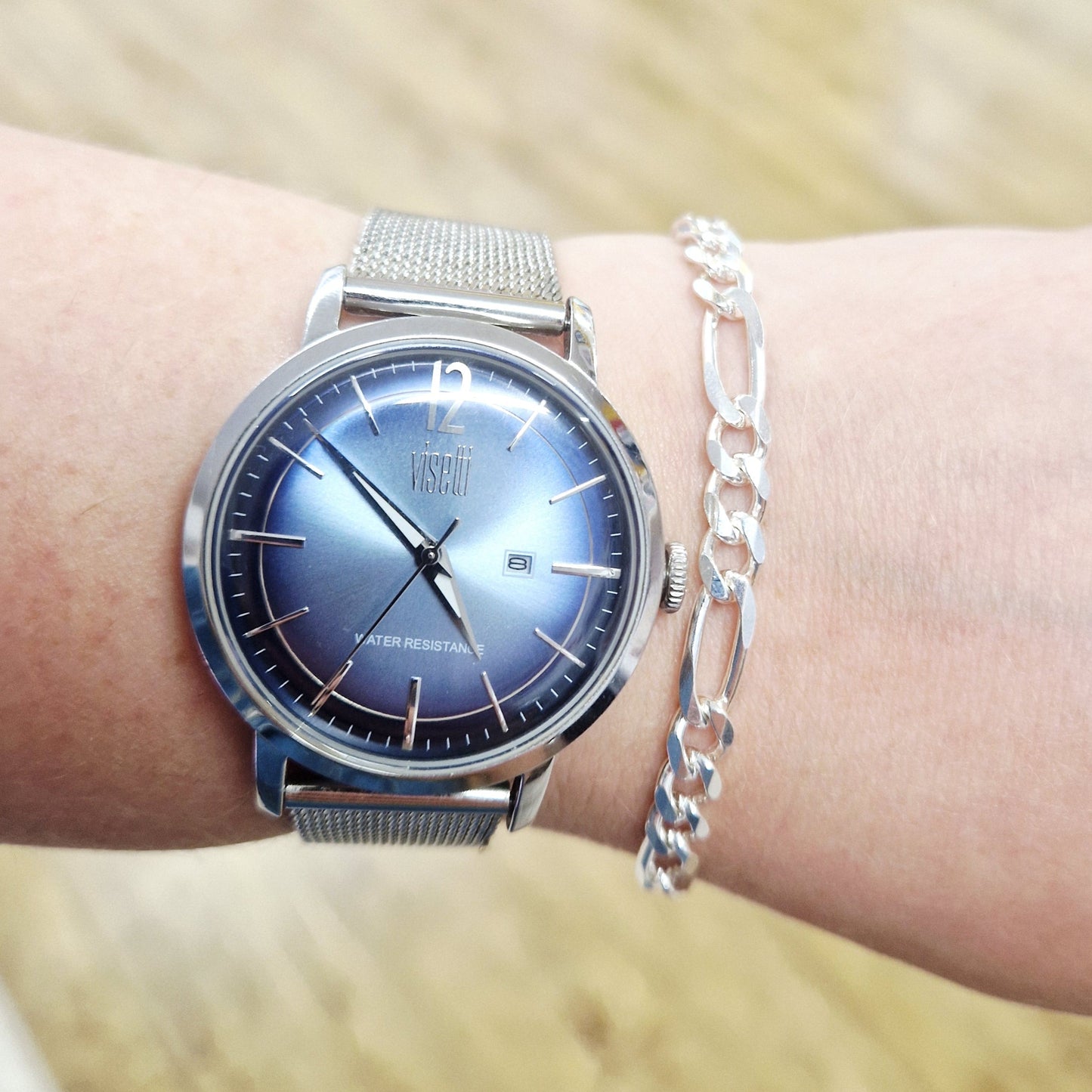 Silver watch on a wrist with a blurred background