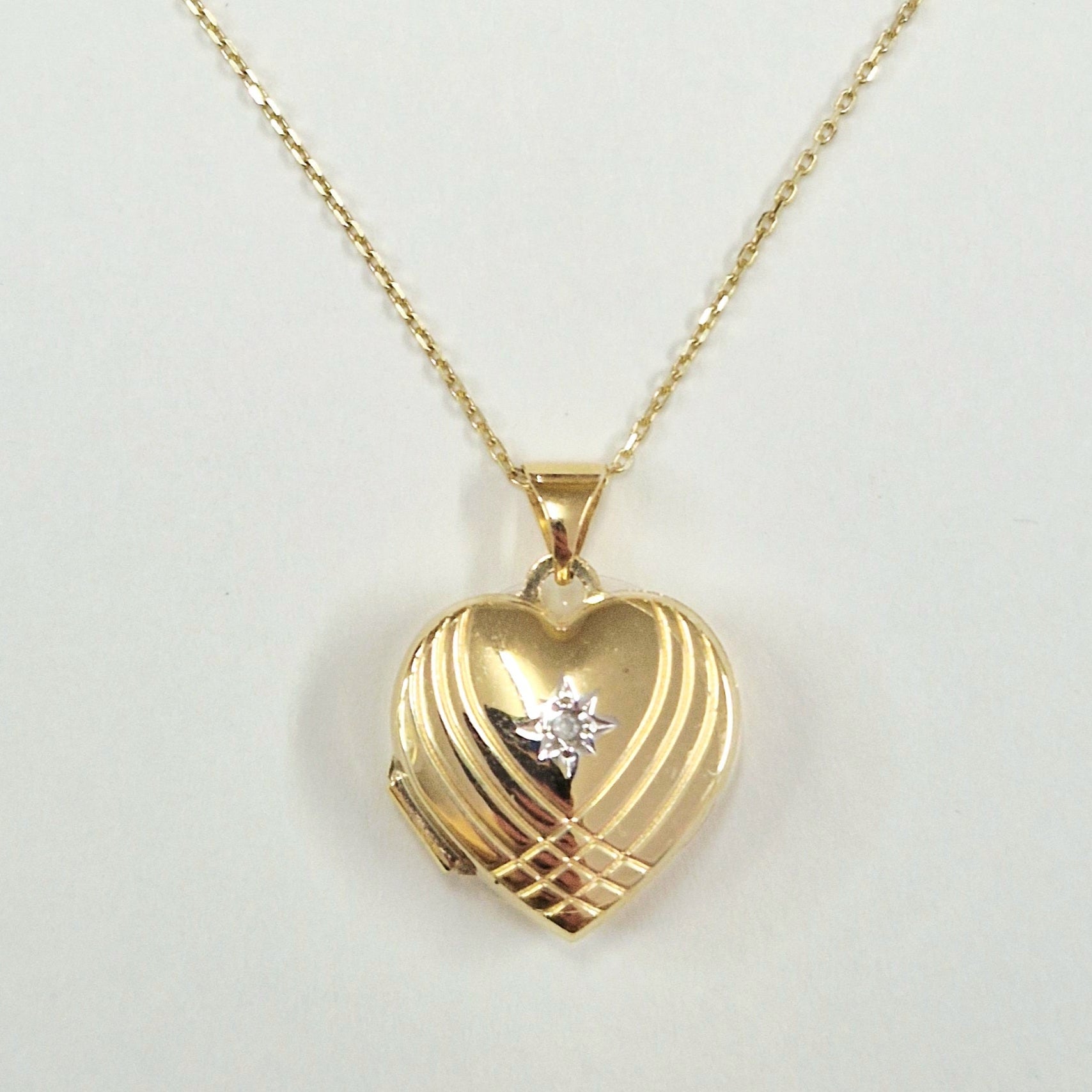 9ct Gold heart locketnecklace on a light gray background
