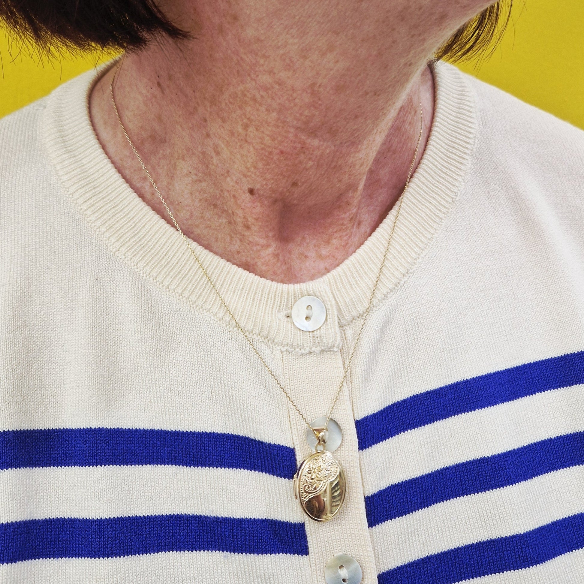 Close-up of a person wearing a blue and white striped shirt with a yellow background