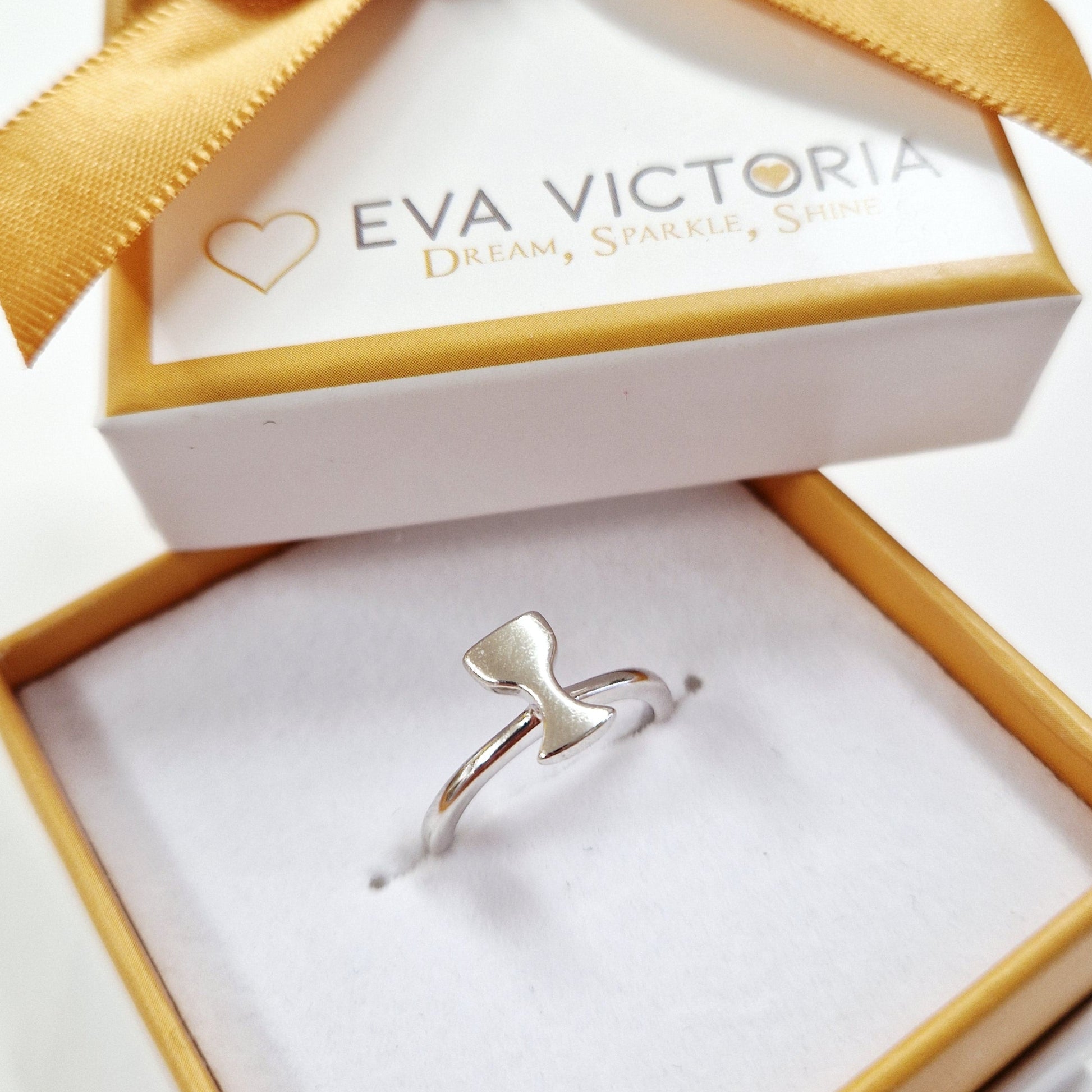 Silver chalice ring in a gold and white box with a gold bow, branded 'Eva Victoria'.