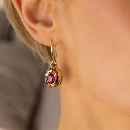 large gold and pink drop earrings on model