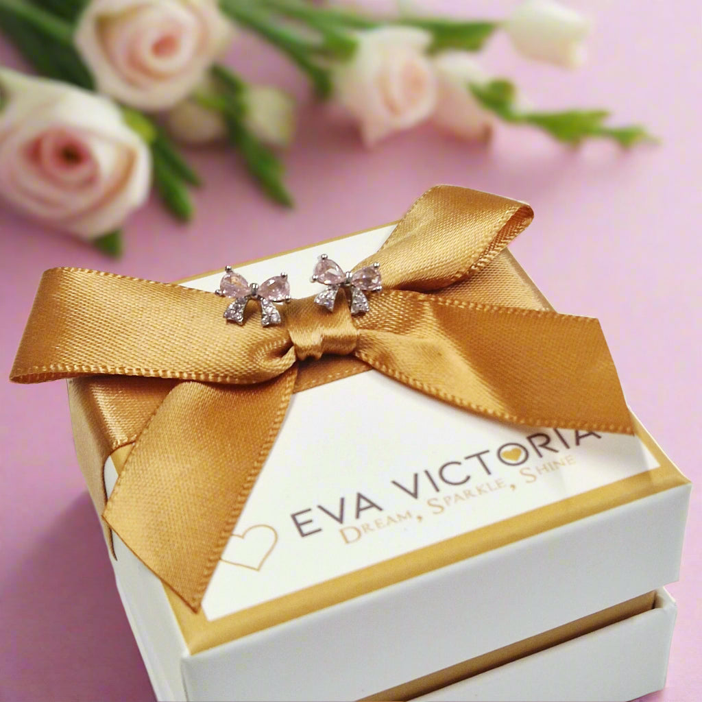 Sterling silver bow-shaped earrings with pink cubic zirconia sparkle