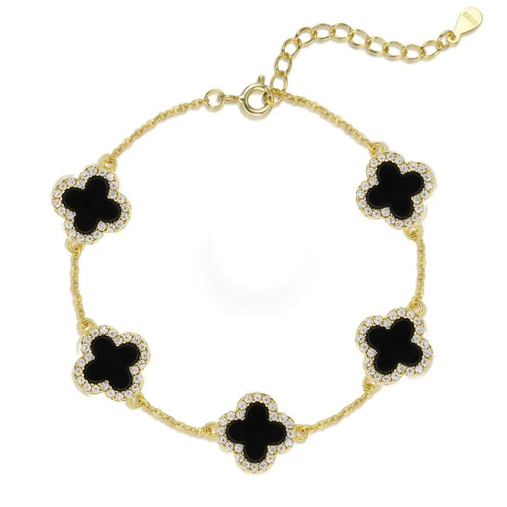 Gold bracelet with black clover-shaped charms on a white background