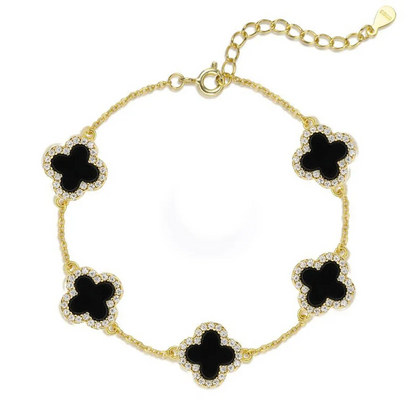 Gold bracelet with black clover-shaped charms on a white background
