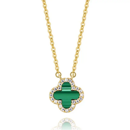 Gold necklace with a green clover pendant on a white background
