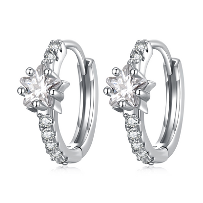 Silver hoop earrings with star-shaped center and diamond-like stones on a white background