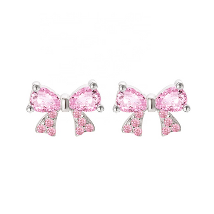 Pink bow-shaped earrings with clear gemstones on a white background