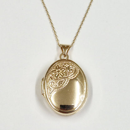 Gold oval locket necklace on a white background