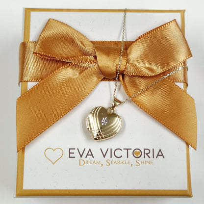 Gold necklace with heart pendant on a branded box