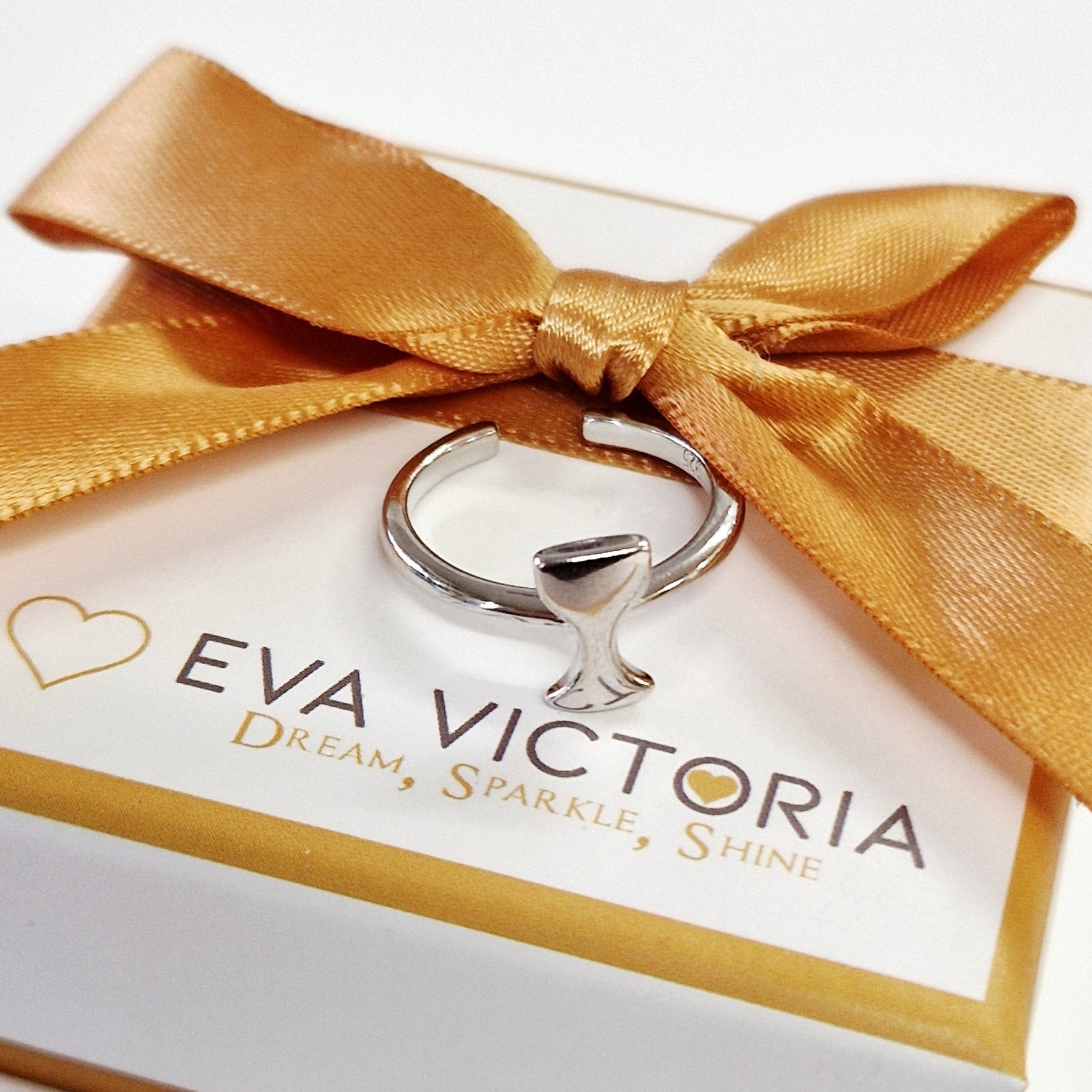 Eva Victoria chalice religeous ring in a white box with a gold ribbon on a light gray background