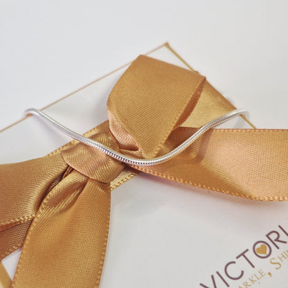 Gift box with a gold ribbon and 'EVA VICTORIA' branding on a white surface.